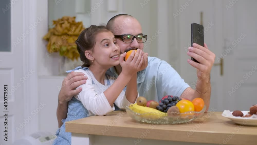 Happy father and daughter in kitchen making a selfie with fruit and vegetable. Food for children. Happy father and daughter in kitchen making a selfie with fruit and vegetable. Food for children.