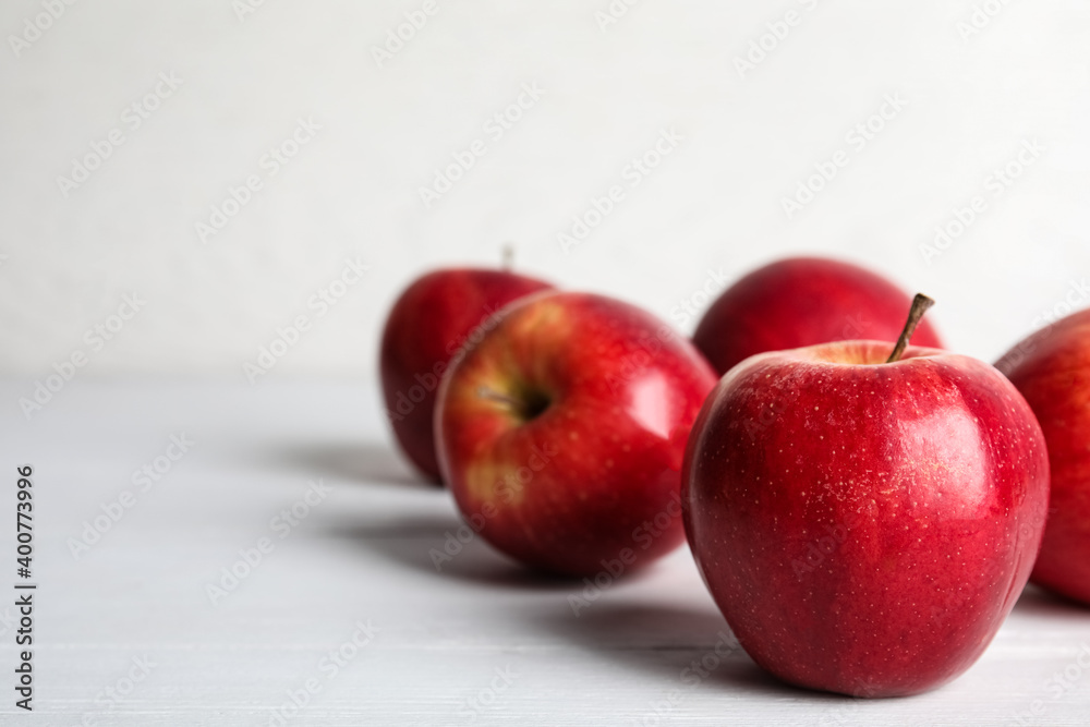 Ripe red apples on white wooden table. Space for text