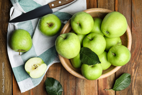 Fotografia Fresh ripe green apples and knife on wooden table, flat lay