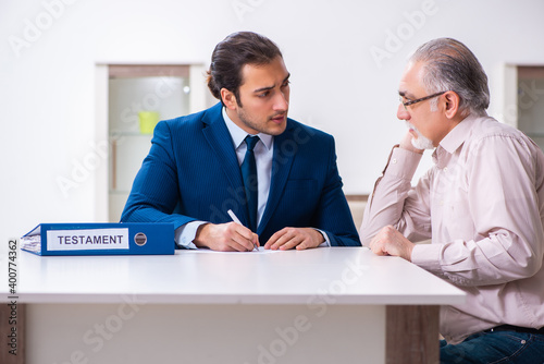 Young male lawyer visiting old man in testament concept photo