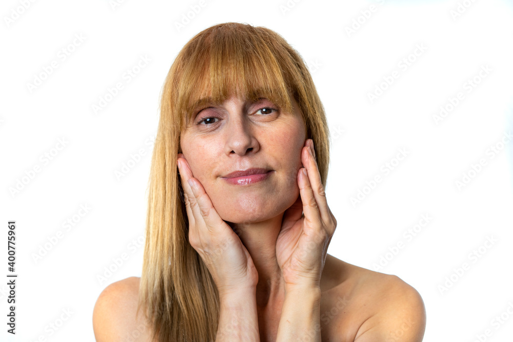 Older woman with blond hair with her hands stretching her face and smiling Older woman with blond hair with her hands stretching her face and smiling
