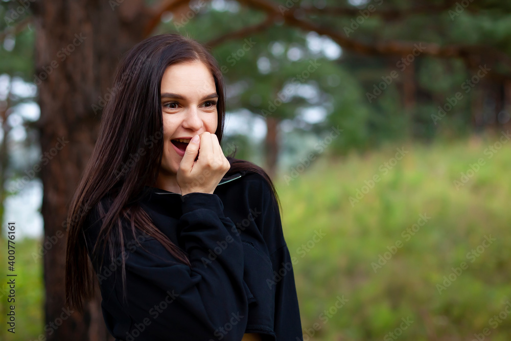 Portrait of beautiful surprised and delighted woman in an outdoor park, she smiles Portrait of beautiful surprised and delighted woman in an outdoor park, she smiles