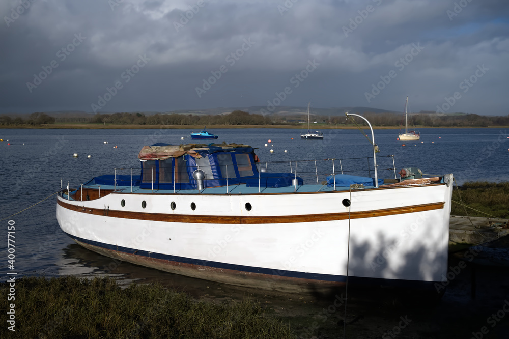 An Elegant old motor boat moored at Dell Quay England on the estuary. An Elegant old motor boat moored at Dell Quay England on the estuary.