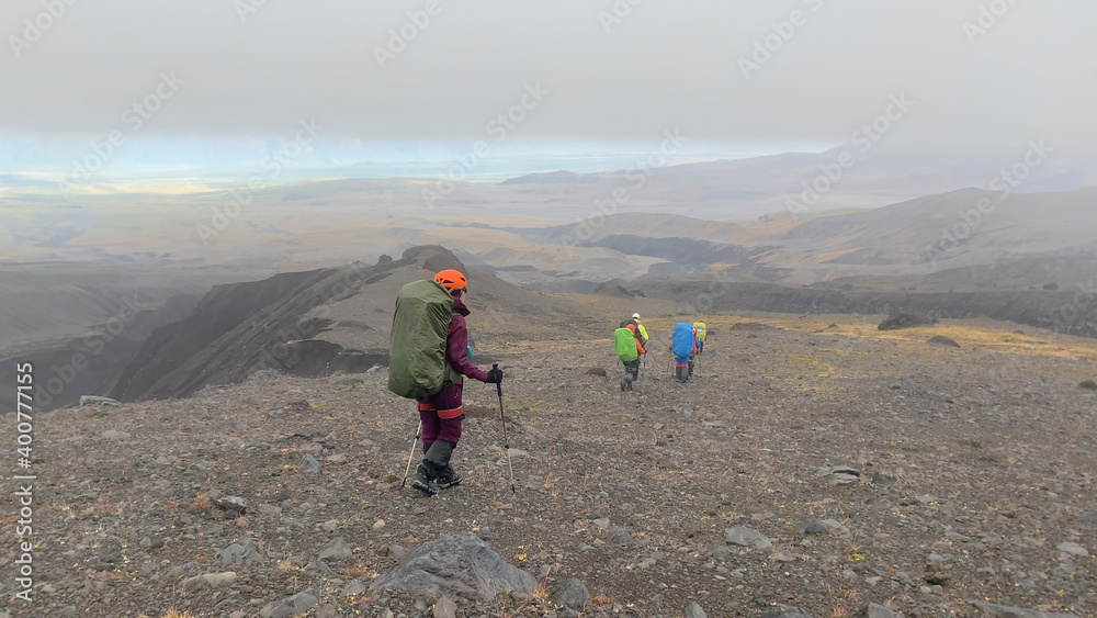 A group of tourists walk through the endless lava fields of Kamchatka.