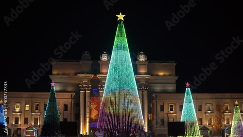 Evening Russia, Samara, Kuibyshev Square, five Christmas trees fully decorated with bulbs glow with different patterns photo