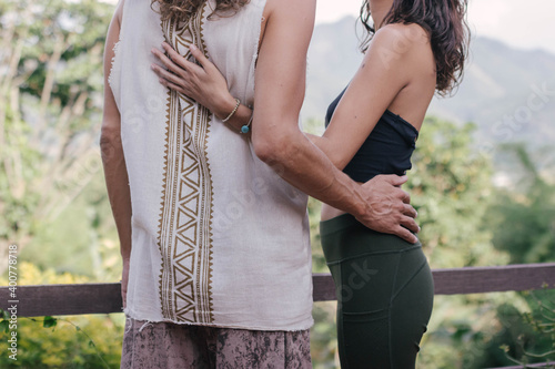White hippie couple hug and support each other in yoga clothers during sunset time in the nature