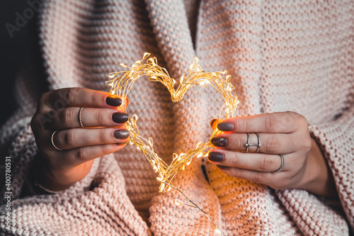 glowing heart in the hands of a woman. Happy Valentine's day