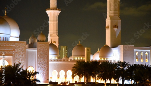 Spiegelung der nächtlich beleuchteten Scheich-Zayid-Moschee auf blanker Wasseroberfläche photo