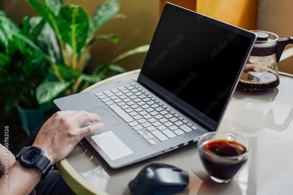Man working on a laptop with blank screen in a fresh and clean outdoor environment with a cup of coffee/tea. Man working on a laptop with blank screen in a fresh and clean outdoor environment with a cup of coffee/tea.