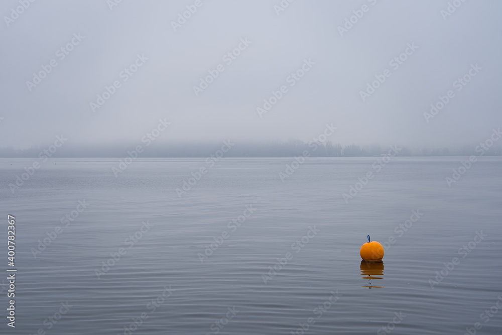 Gelbe Boje im Nebel am See
