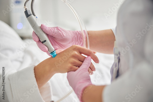 Doctor in sterile gloves using a dermabrasion device