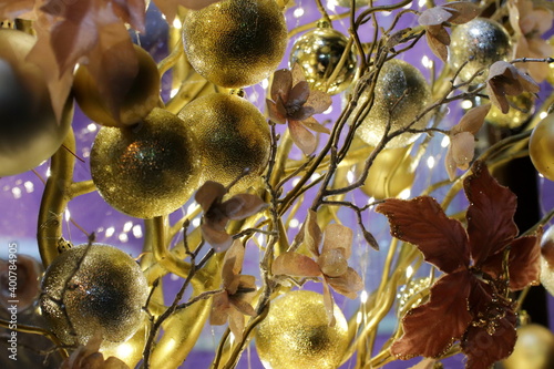 New Year's festive decorations of manors in yellow shades on a purple background. Christmas decorations. Festive room design. Artistic work. Fun mood. The atmosphere of a fairy tale and mystery