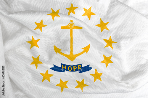 The Rhode Island flag is a white field with a yellow anchor above a ribbon that reads HOPE. The anchor and ribbon are surrounded by thirteen yellow stars. 