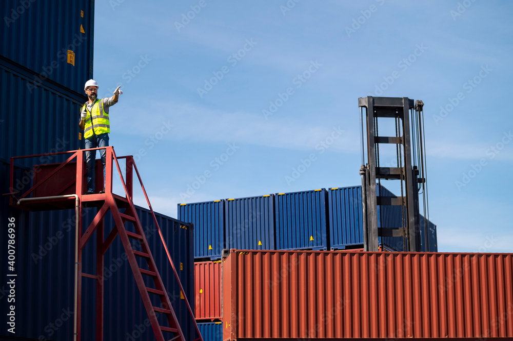 Logistics engineer stand on and Pointing up around Shipping container stacker in commercial transport port