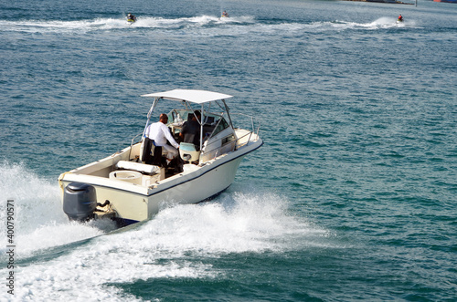 Foto Small open fishing boat powered by a single outboard engine.