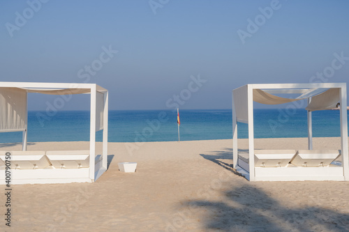 Relaxing empty beach with sun bed  sea landscape. Summer vacation travel holiday concept.