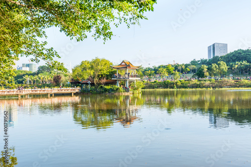 Lake, island,  green forest and Chinese traditional pavilion against blue sky in longtan Park, Longgang, Shenzhen, China