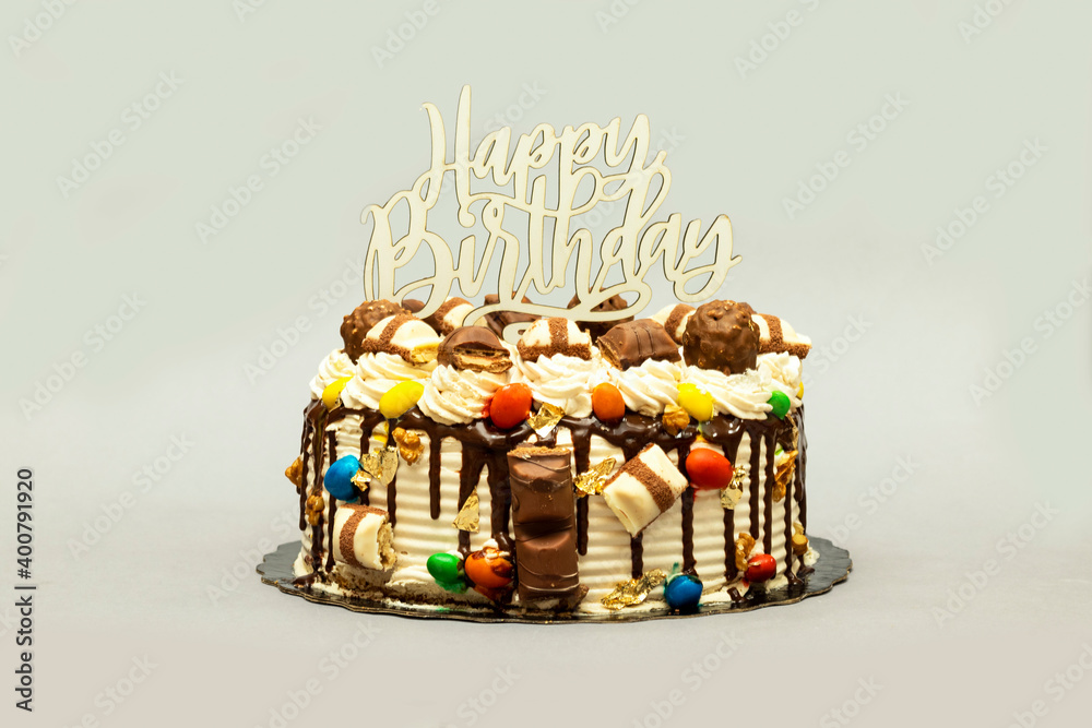 Birthday layer cake decorated with chocolate pieces with happy birthday text