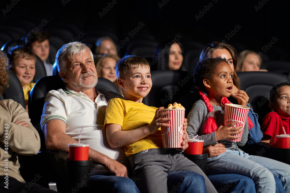 People with little kids on knees in cinema.