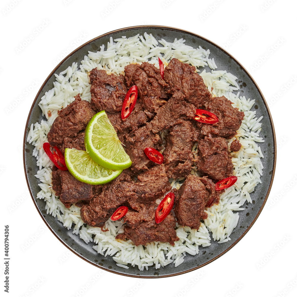 Beef Rendang on black plate isolated on white. Indonesian padang cuisine meat dish. Asian food. Top view Beef Rendang on black plate isolated on white. Indonesian padang cuisine meat dish. Asian food. Top view