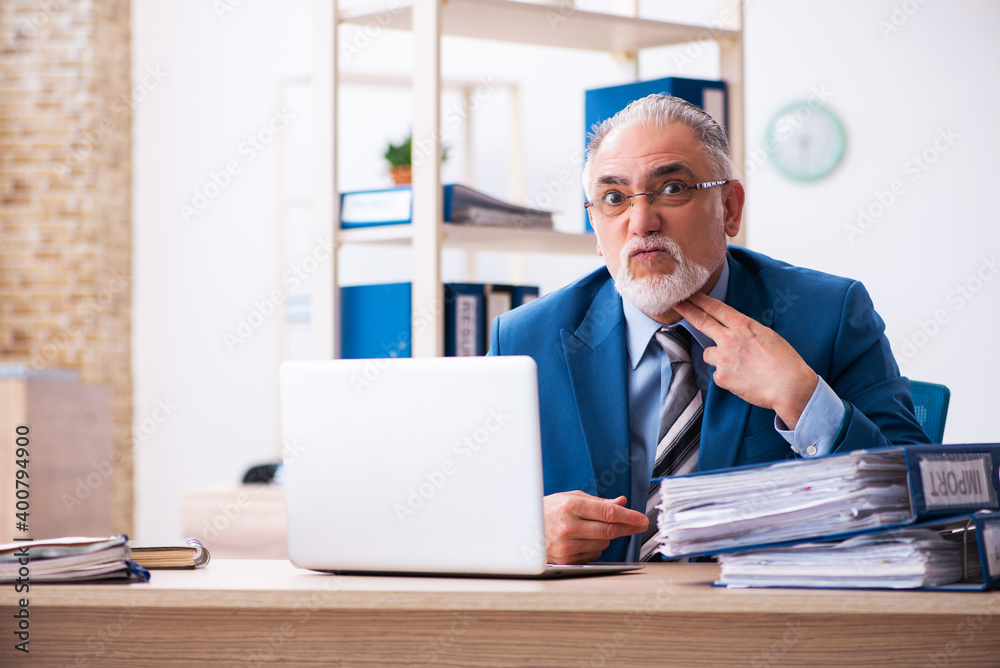 Old male bookkeeper unhappy with excessive work at workplace Old male bookkeeper unhappy with excessive work at workplace