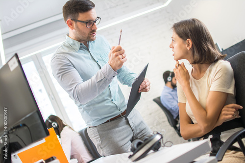 Bilde på lerret Male boss threatening with pen his female employe in the office.