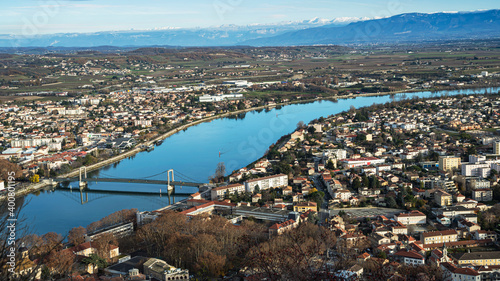 Panoramic view of the french Tournon city with the old bridge underneath and snowy Alps mountains on the background.