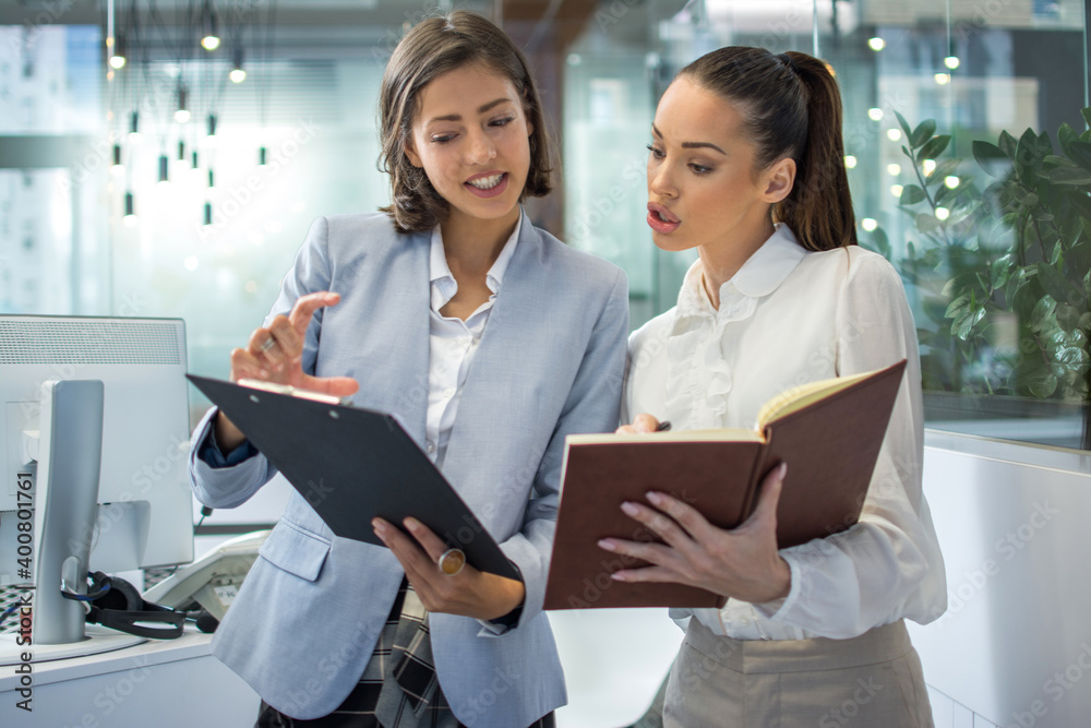 Two attractive business women working together in office. Two attractive business women working together in office.