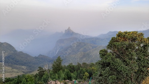 beautiful scenic view from Kodanad View Point of misty rain cloud hill mountain green forest photo