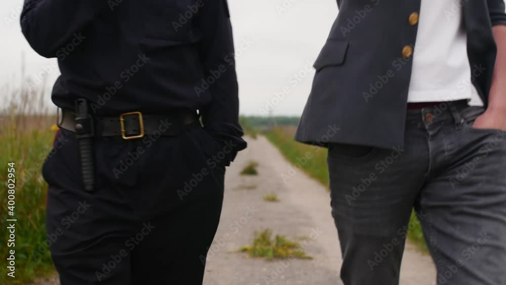 Two Russian police officers are walking along the path in the countryside. Two Russian police officers are walking along the path in the countryside.