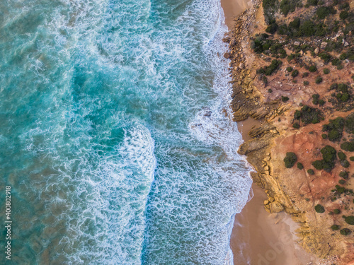 Top down aerial drone shot of waves crashing on beach (Algarve/Portugal)
