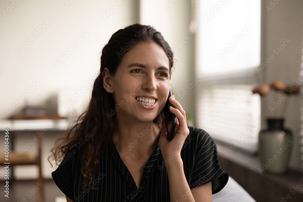 Close up of smiling young Caucasian woman talk speak on cellphone with friend or colleagues. Happy millennial female client or user have pleasant smartphone conversation. Communication concept. Close up of smiling young Caucasian woman talk speak on cellphone with friend or colleagues. Happy millennial female client or user have pleasant smartphone conversation. Communication concept.