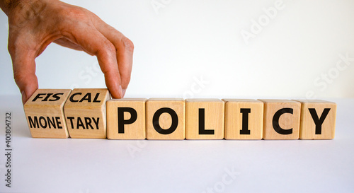 Fiscal or monetary policy symbol. Hand turns cubes and changes words 'fiscal policy' to 'monetary policy'. Beautiful white background. Business and fiscal or monetary policy concept. Copy space.