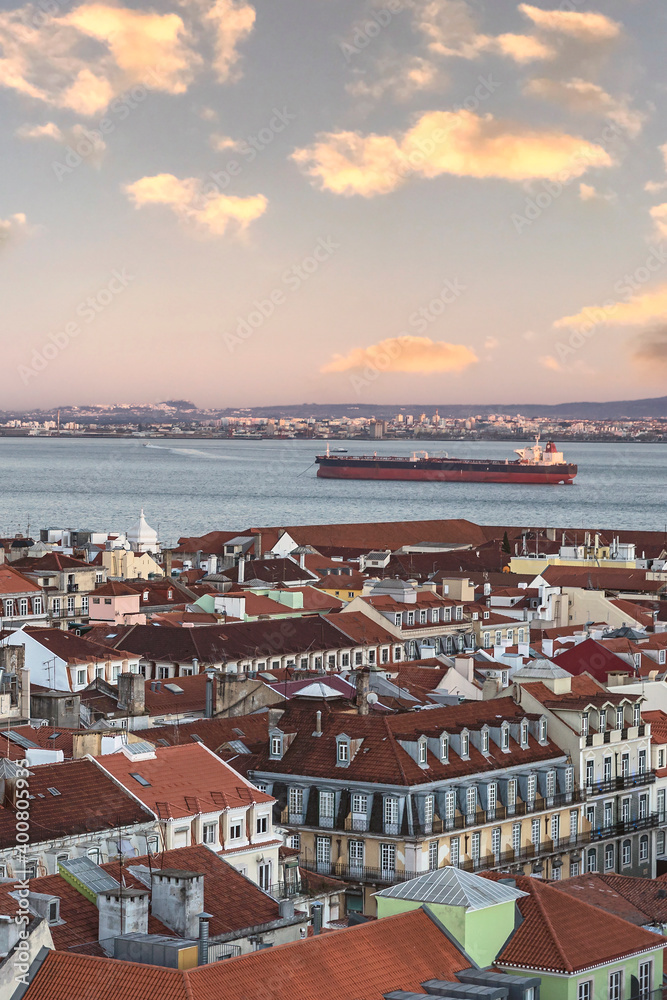 view of the red roofs of the city and the wide river with a large ship in the capital of Portugal - Lisbon