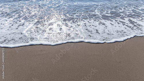 Sparkling waves hitting the shore on the beach on sunny day at Summer  sand beige background image  Holiday  Travel Concept in Antalya Turkey.