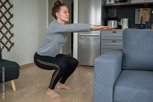 Woman doing fitness at home in kitchen or living room