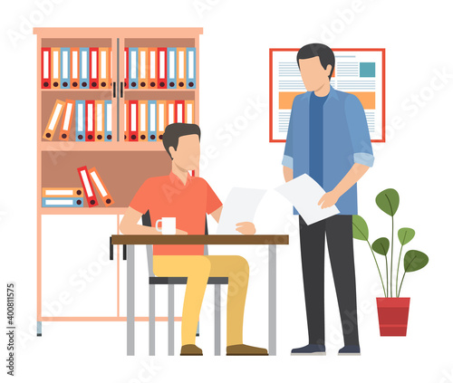 Business meeting colleagues or partners. Businessman chief sitting at desk in office interior listening to manager s explanation. Two men holding paper sheets talking at the table in the office space