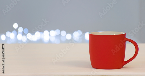 Empty red cup with free space for text or emblem with bokeh lights on background. Banner for coffee house  barista or winter drink blank with copy space.