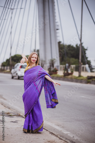Young european woman with short hair in purple traditional saree. Outdoor portrait. India, Bangalore