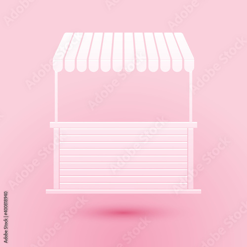 Paper cut Street stall with awning and wooden rack icon isolated on pink background. Kiosk with wooden rack. Paper art style. Vector.