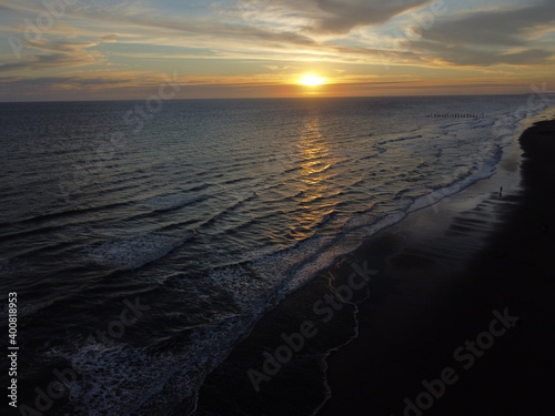 Sunset on Atlantic ocean Argentine coasts, brown sand and blue waves, picture with a drone. Monte Hermoso, Argentina photo