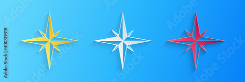 Paper cut Wind rose icon isolated on blue background. Compass icon for travel. Navigation design. Paper art style. Vector.