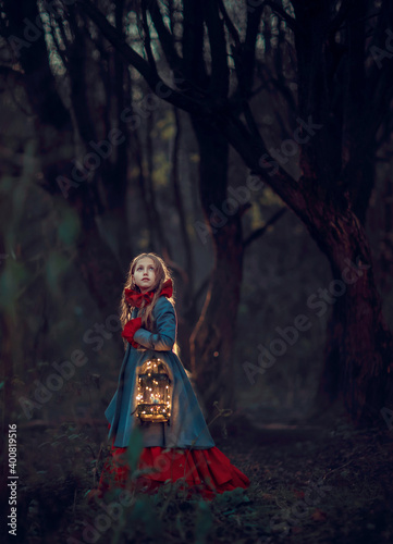 Girl with cage and bird in the night autumn forest