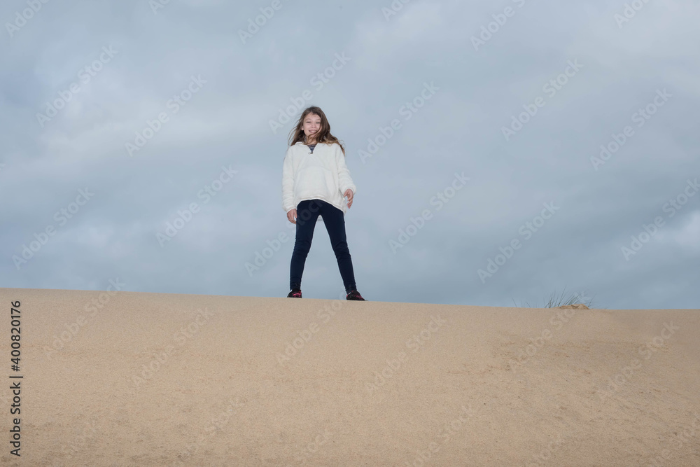 cute young girl running in the dunes in autumn cute young girl running in the dunes in autumn