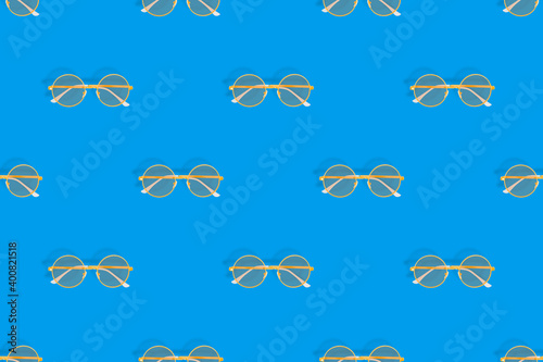 Background on the theme of glasses for vision. Glasses seamless pattern on a blue background.