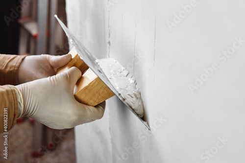 Картината върху платно Close up of construction worker hands plastering and smoothing wall with a trowel