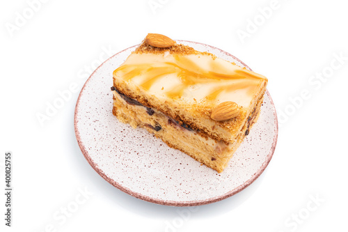 Honey cake with milk cream, caramel, almonds isolated on a white background. Side view.