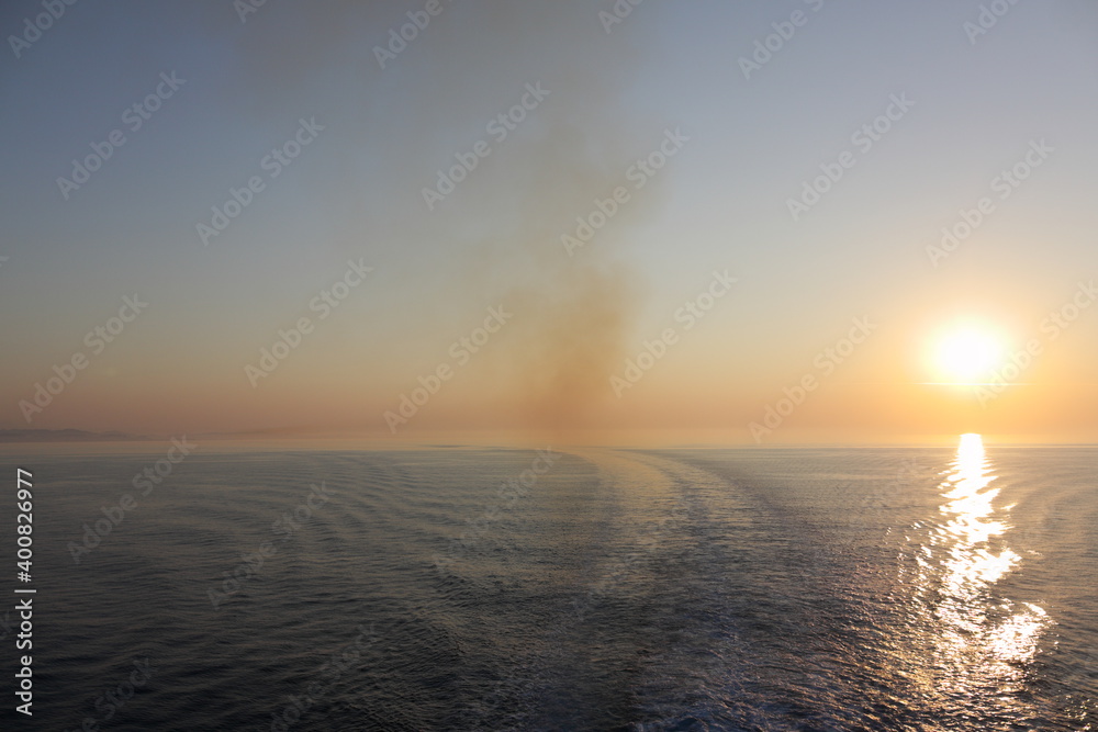 sunrise over the sea with ferry smoke