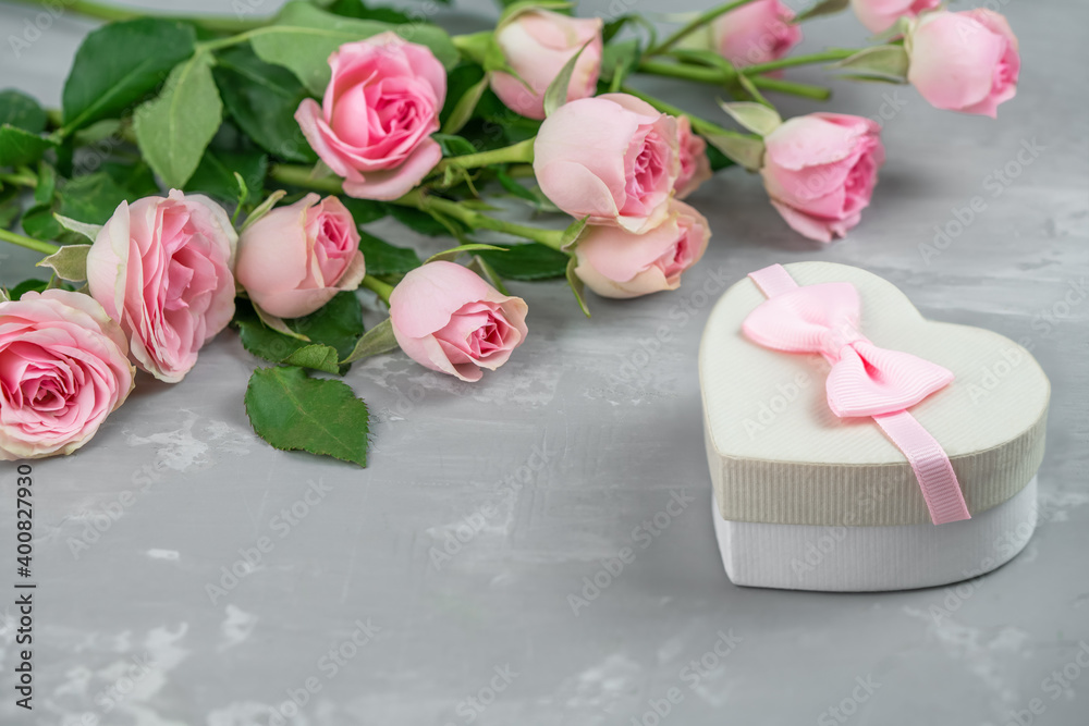 Gift box and a beautiful bouquet of pink roses on a gray background Gift box and a beautiful bouquet of pink roses on a gray background