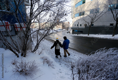 un couple marche dans une rue enneigée en hiver photo